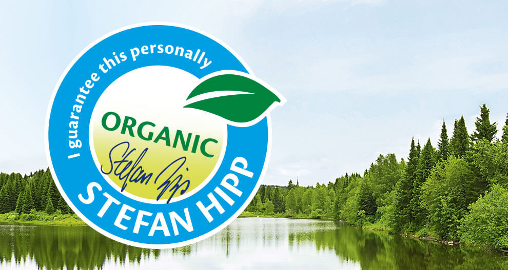 A circular badge with the text "I guarantee this personally" and "Stefan Hipp" is superimposed on a scenic image of a lake surrounded by trees.