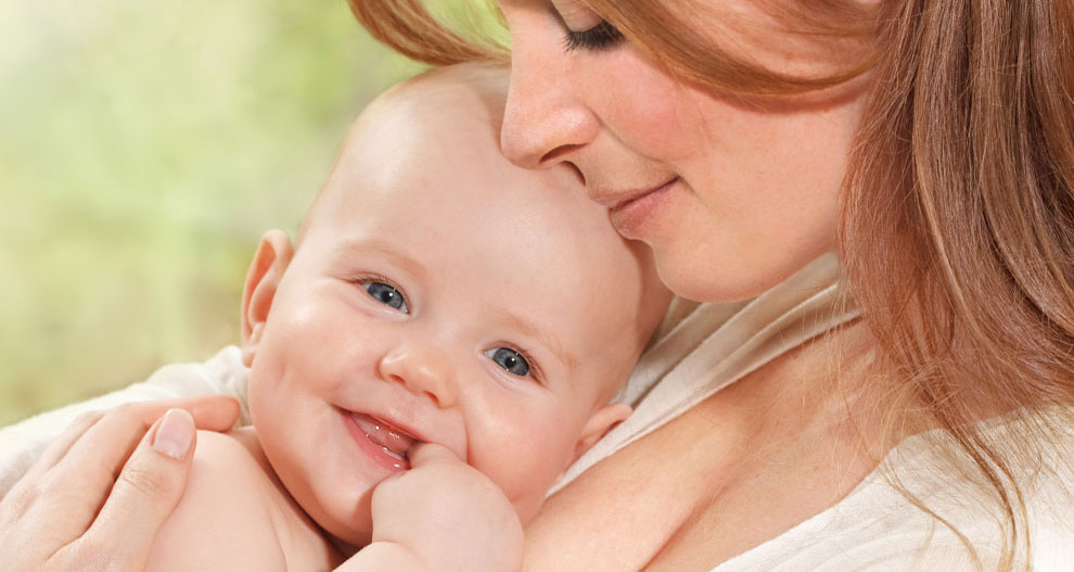 A mother lovingly holds her baby.